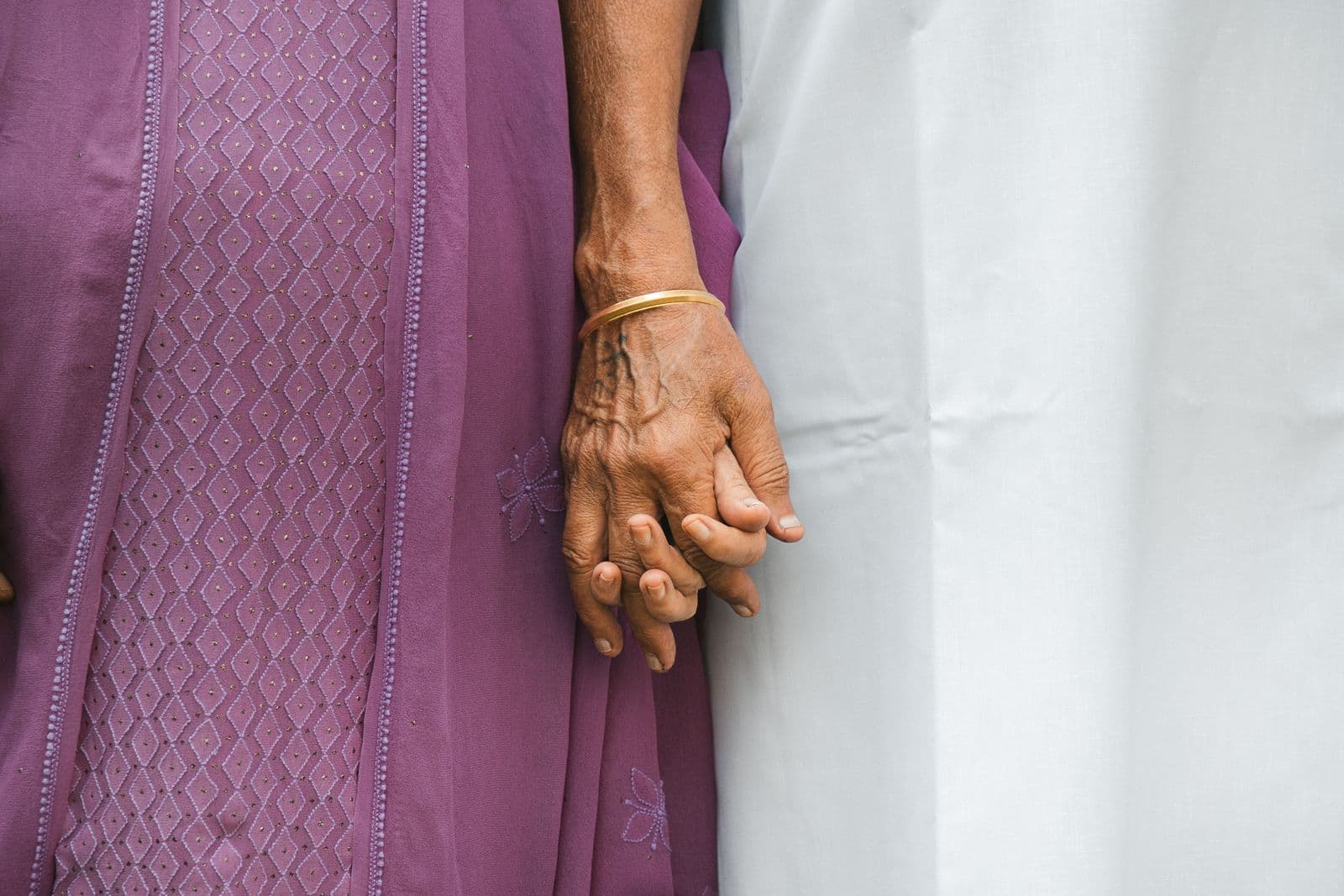 An elderly woman’s hand held by a younger family member